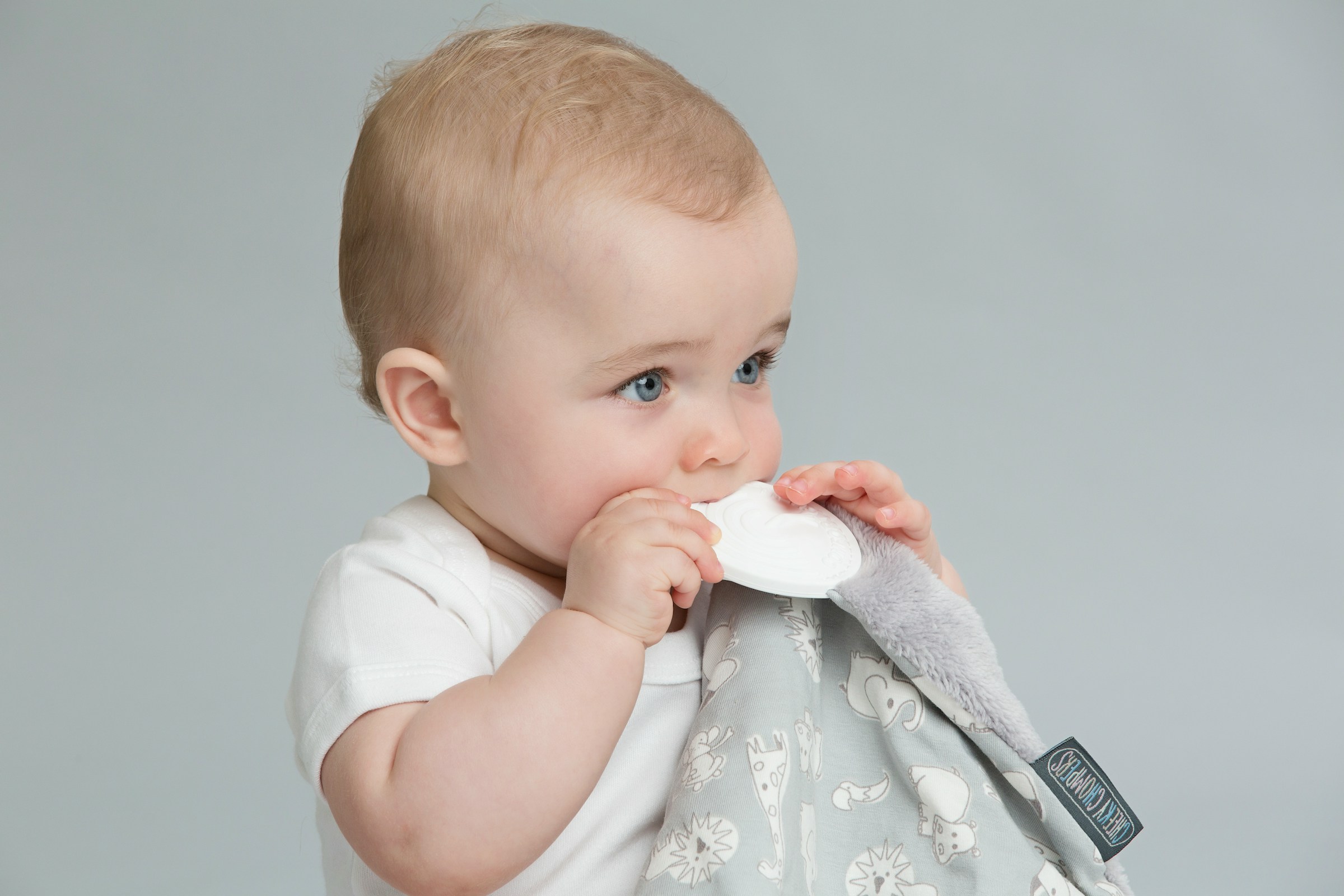Baby chewing on plastic toy