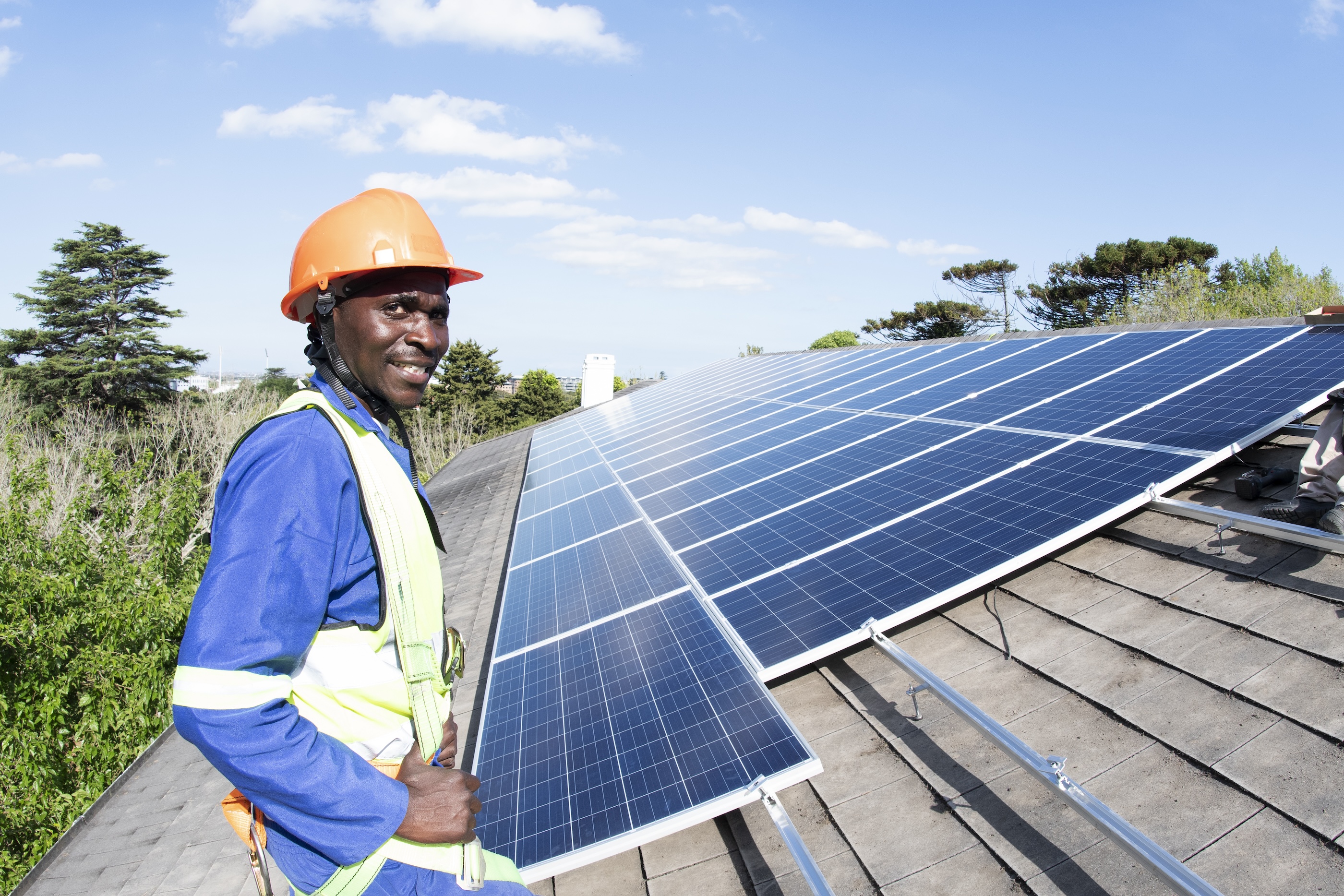 Worker installing solar panels on roof Worker installing solar panels on roof